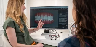 Dentystka omawia z pacjentką plan leczenia na ekranie zębów.
