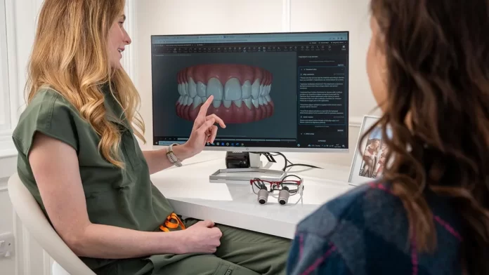 konsultacja-przed-leczeniem-implantologicznym Dentystka omawia z pacjentką plan leczenia na ekranie zębów.