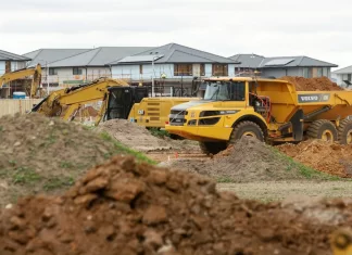 Transport urobku na ciasnym placu — kiedy wozidło bije wywrotkę Przegubowe wozidło transportuje urobek między pryzmami ziemi na osiedlu.